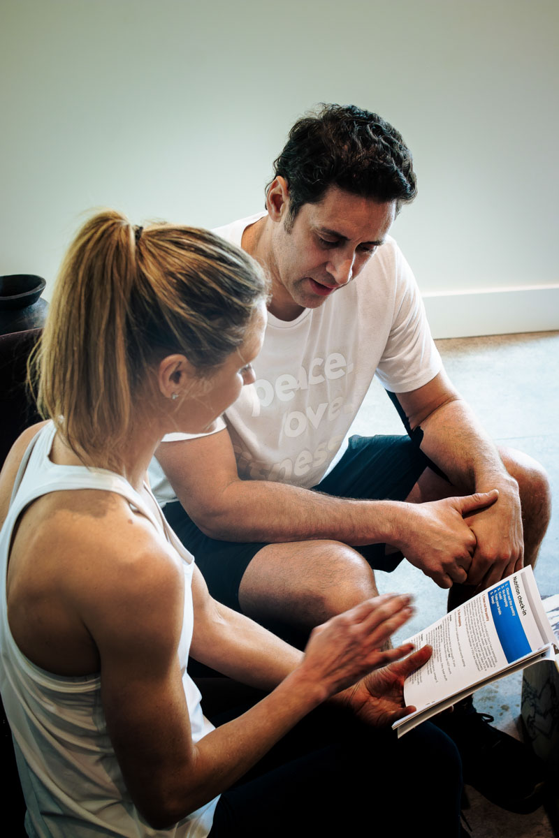 Man in white tee and woman in white tank looking at health assesment